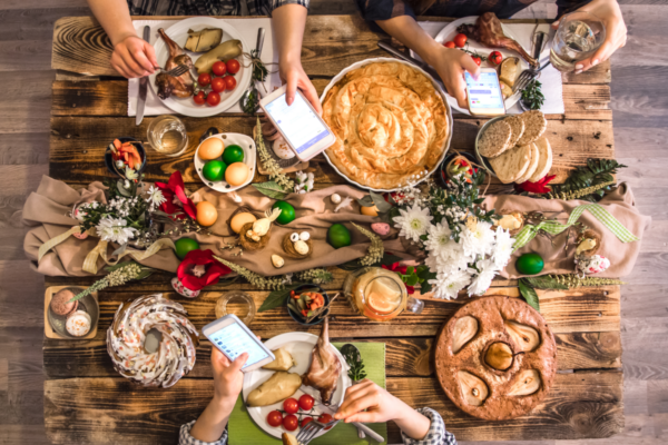 Scena di pranzo o cena aziendale visto dall'alto su tavola in legno imbandita di cibi e bevande